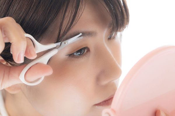 眉の手入れ カットする女性 